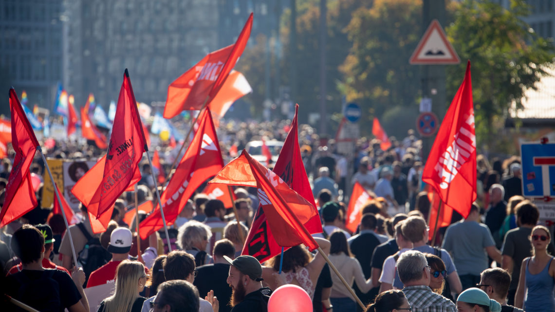 Block von DIE LINKE auf der Demonstration "#Unteilbar" im Oktober 2018 in Berlin. Zu sehen sind DIE LINKE-Fahnen in einer Menschenmenge.