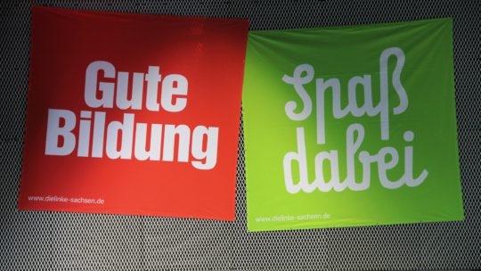 Zu sehen sind zwei Banner. Auf einem roten steht weiß: "Gute Bildung". Daneben ein grünes Banner, dort steht: "Spaß dabei".